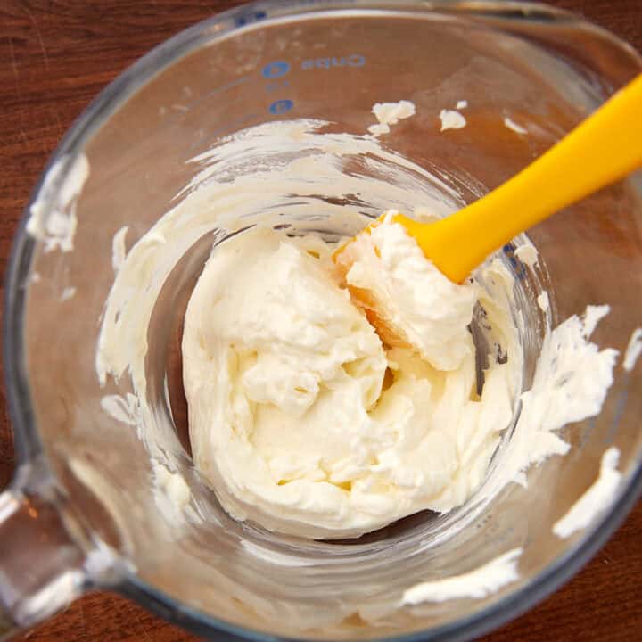 A bowl of softened cream cheese.