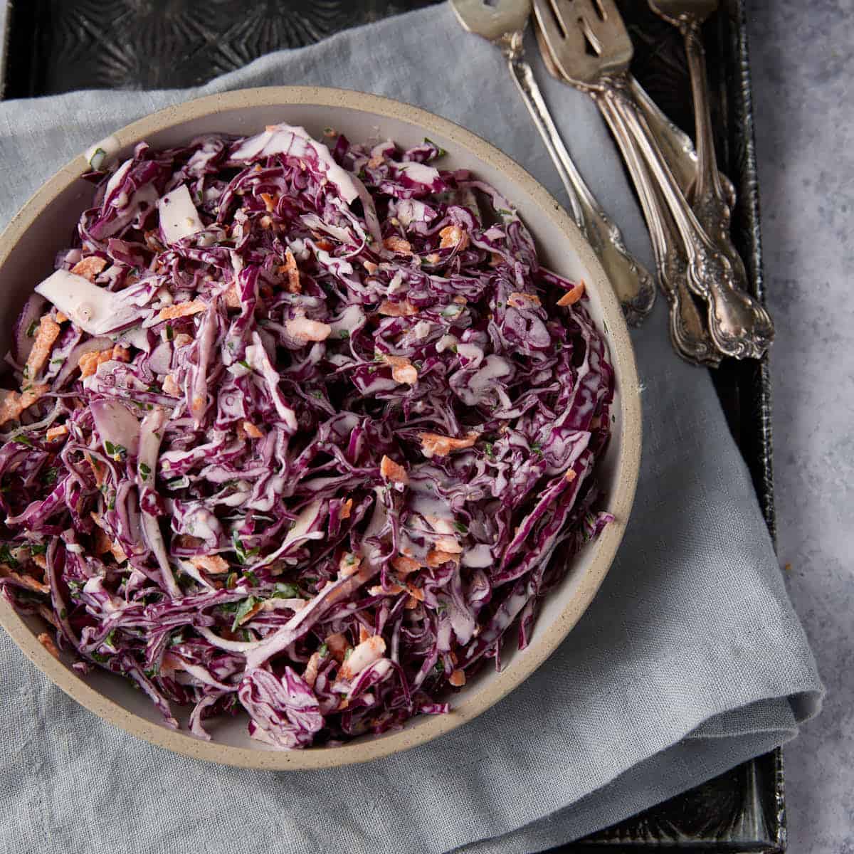 Red cabbage coleslaw in a dish on a linen napkin.