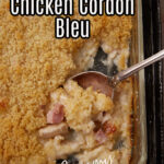 A serving spoon in a baking dish of chicken cordon bleu.