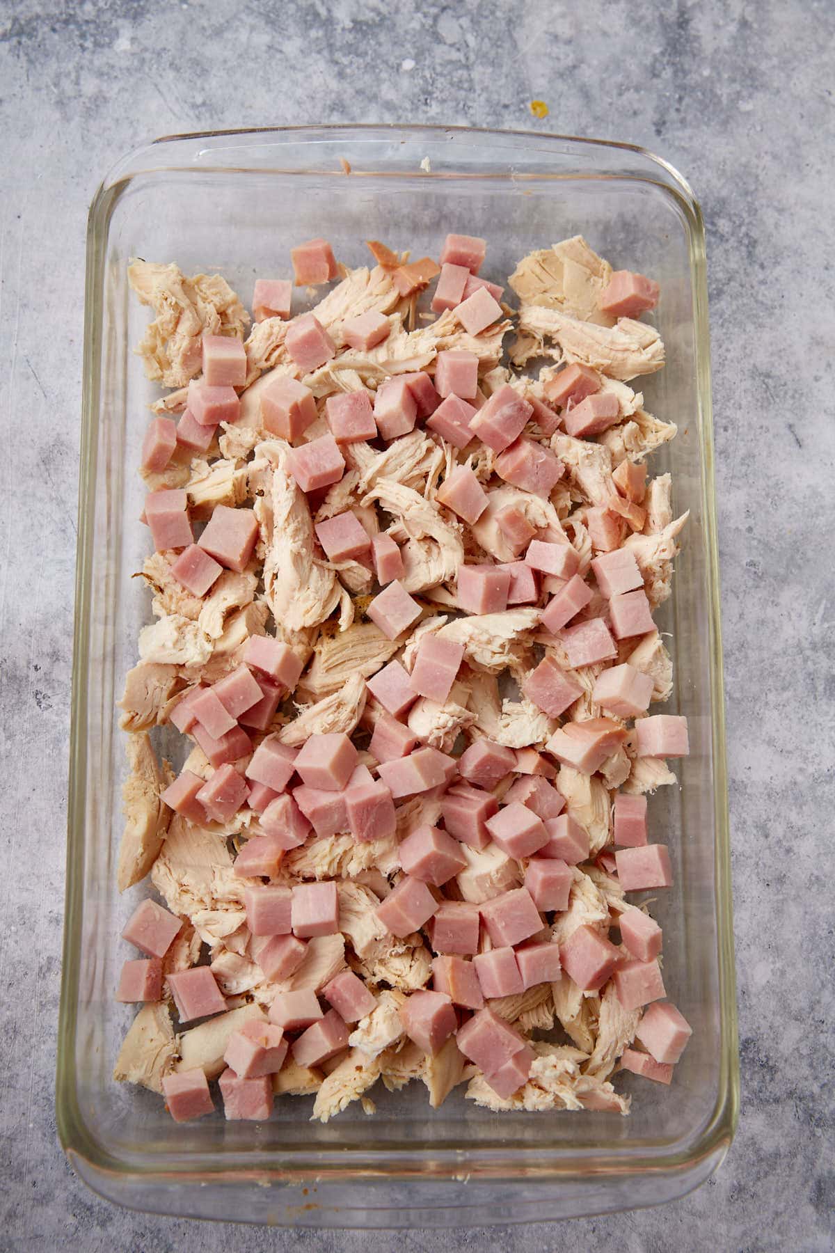 Chicken and ham layered in a casserole dish.