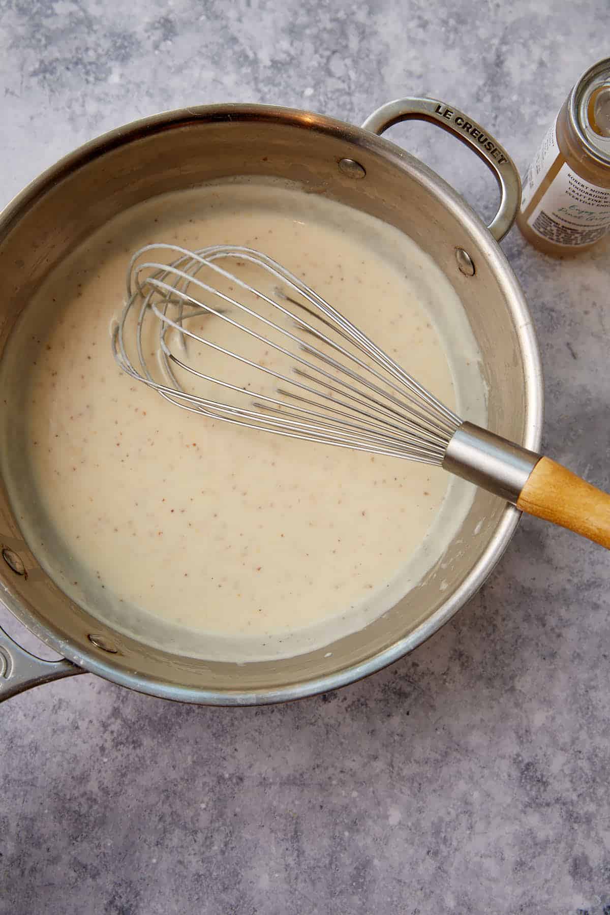 A roux in a saucepan wiht a whisk.