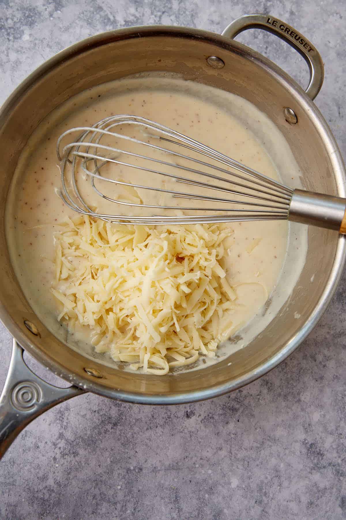 Cheese added to a roux in a saucepan.