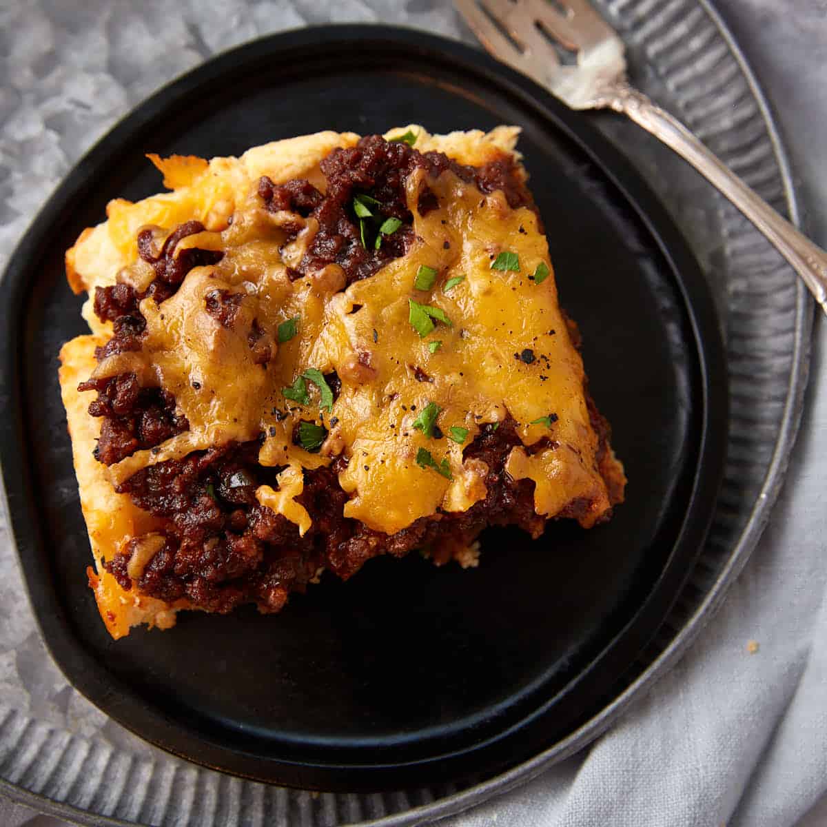 A serving of hamburger casserole with biscuits on a plate.