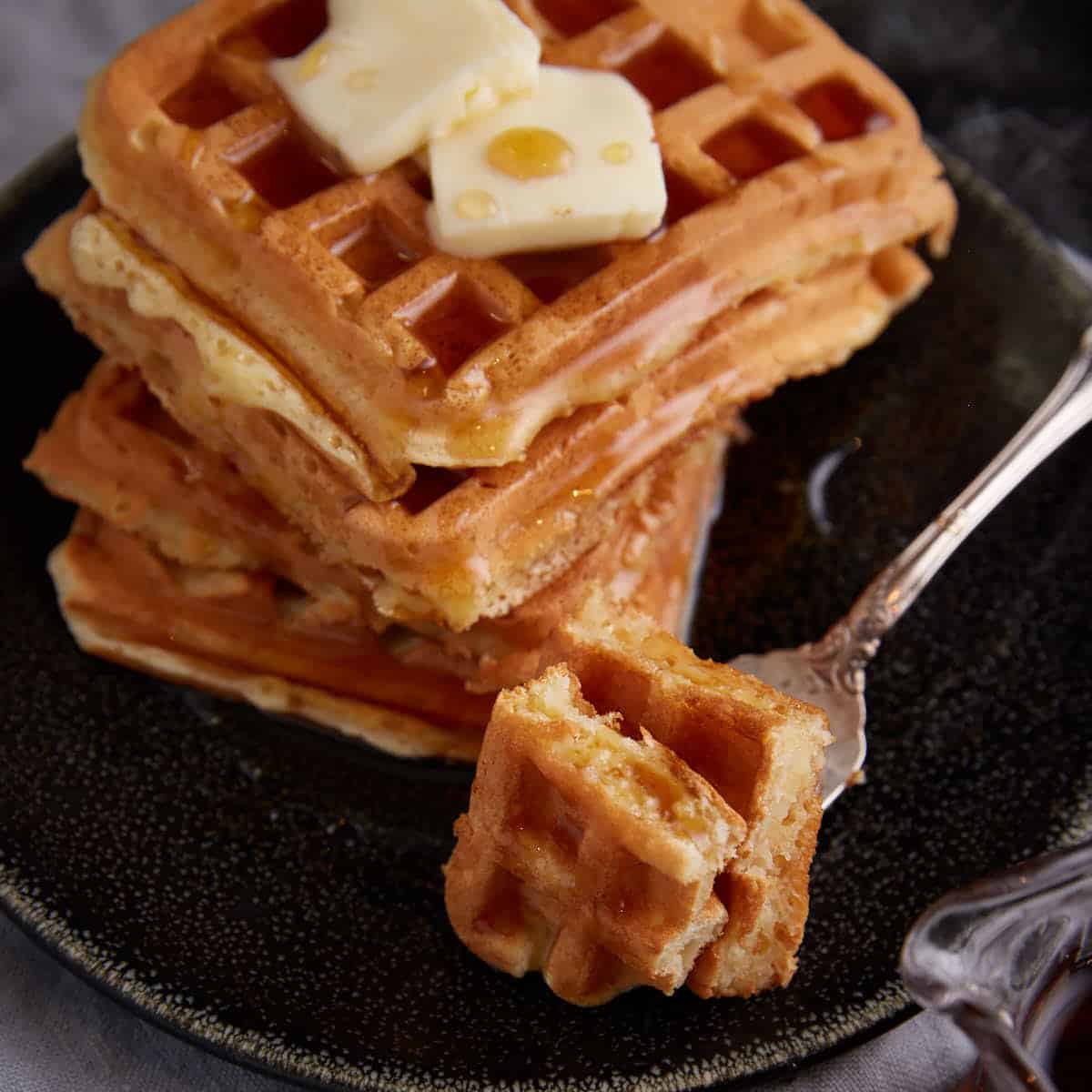 A bite of waffle on a fork.