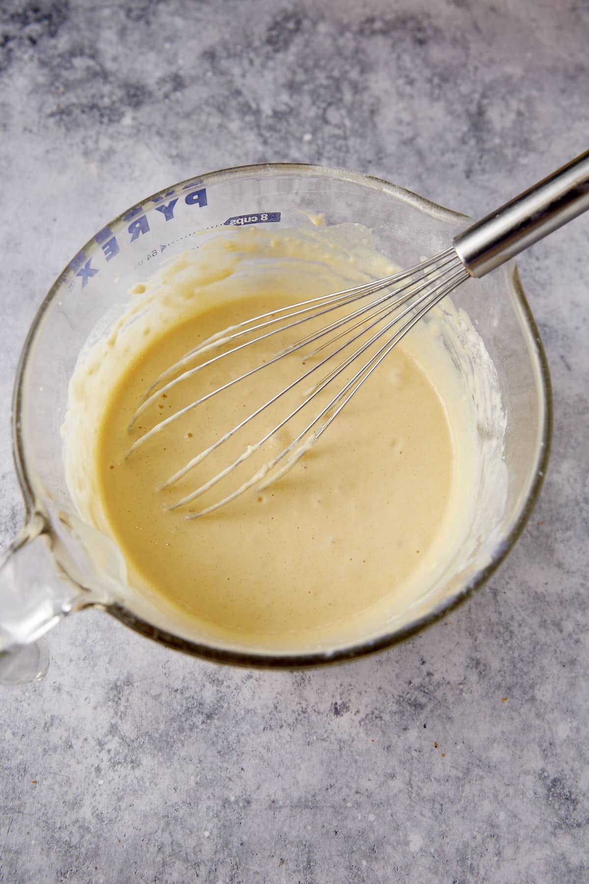 Dry and wet ingredients combined in a bowl with a whisk.