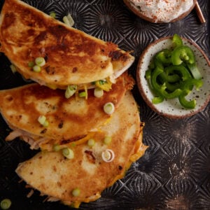 Three stuffed tortillas with toppings.