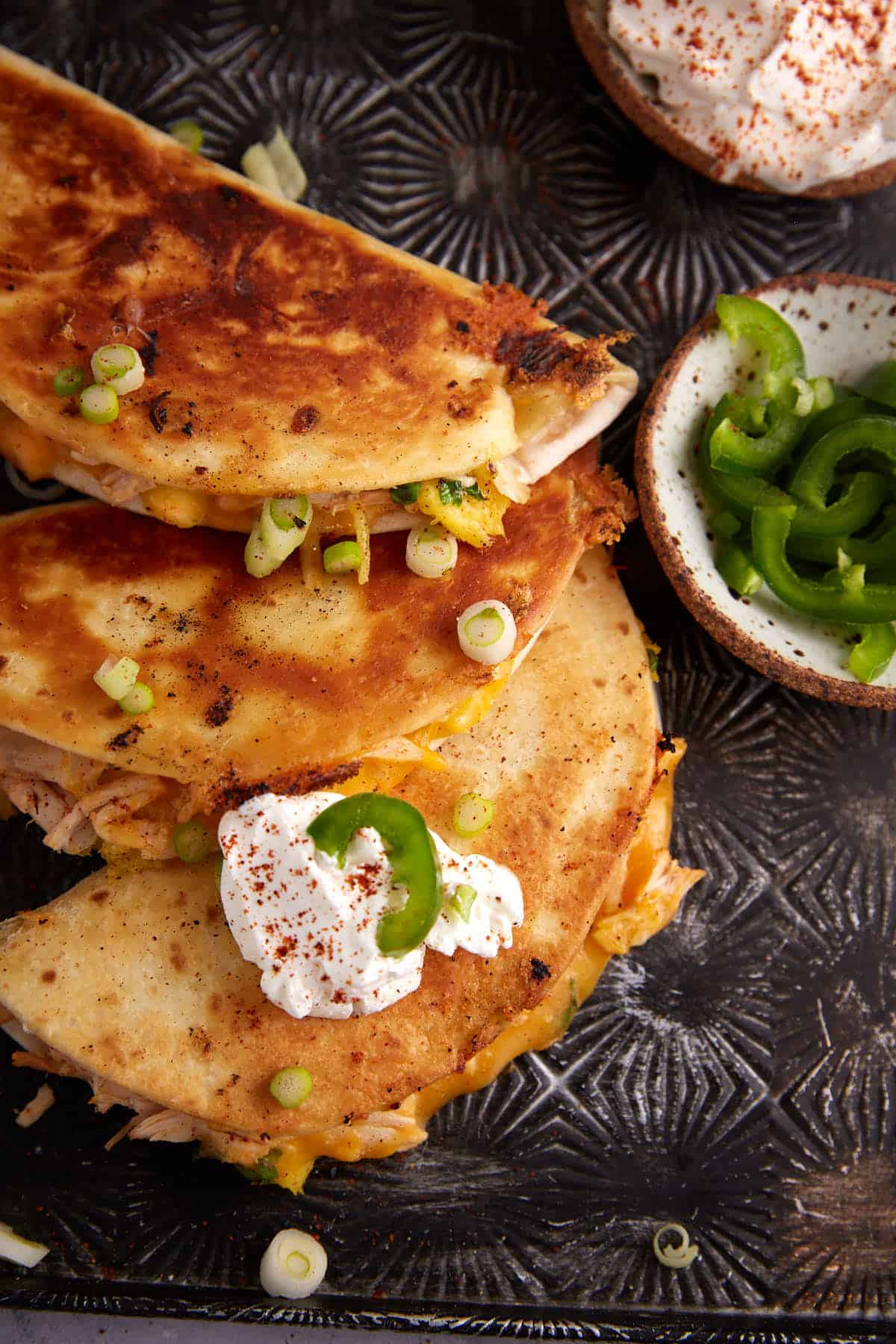 A quesadilla topped with sour cream.