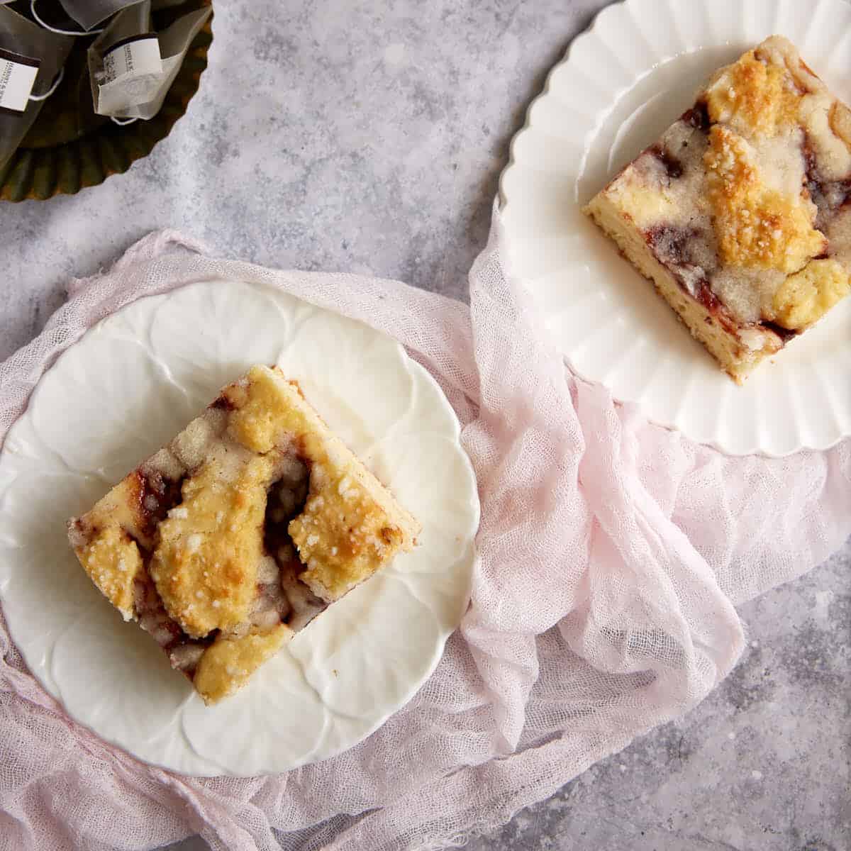 Two pieces of strawberry coffee cake on plates.