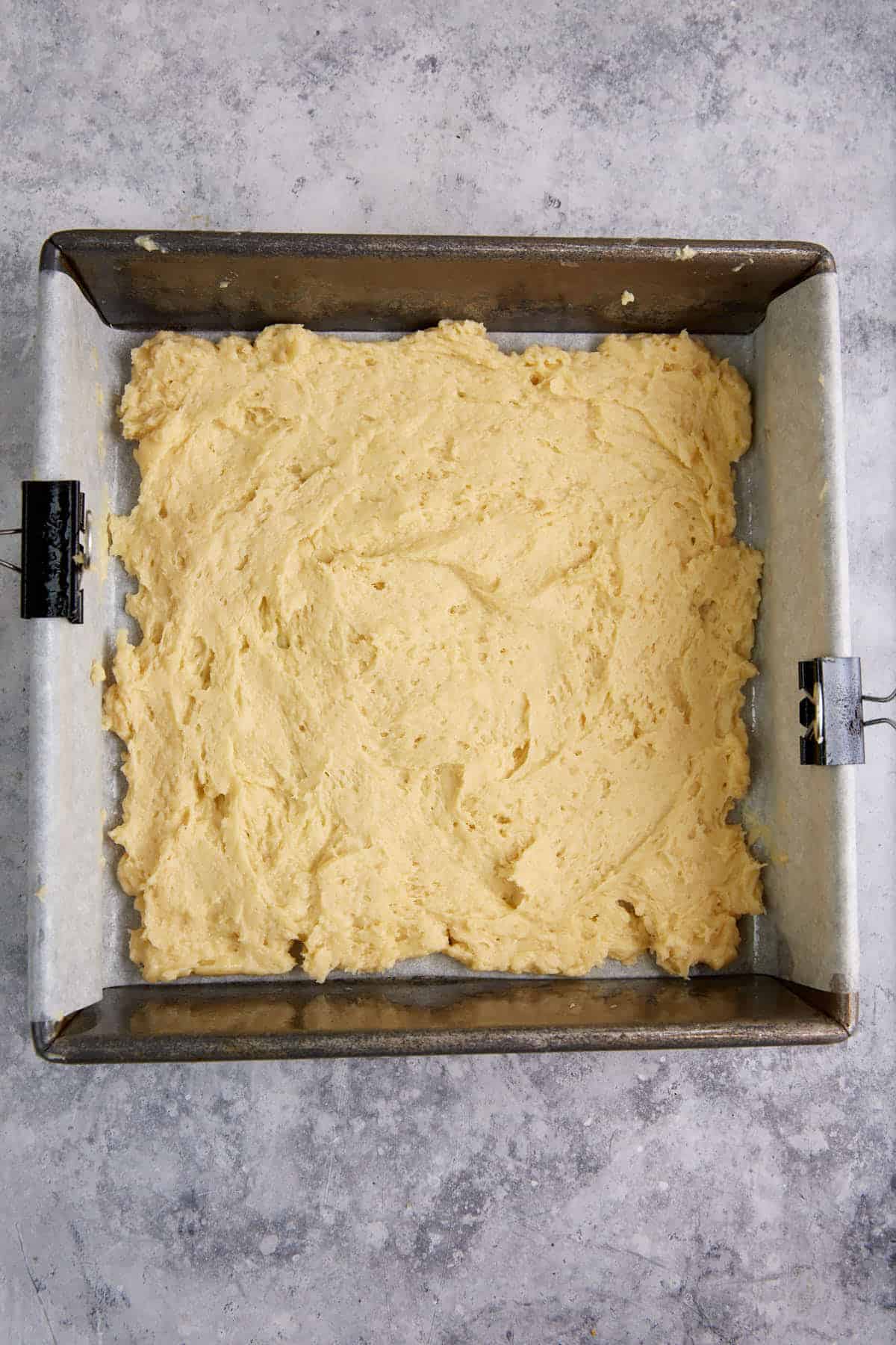 Cake batter in the bottom of a baking pan.