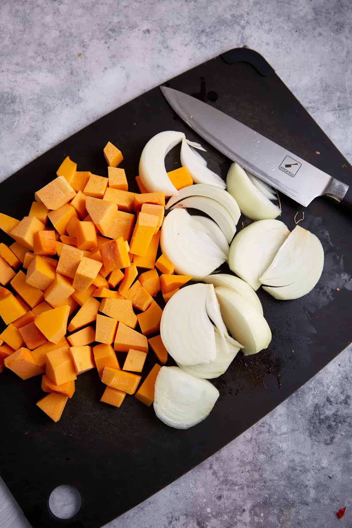Chopped vegetables on a cutting board for a butternut squash casserole.