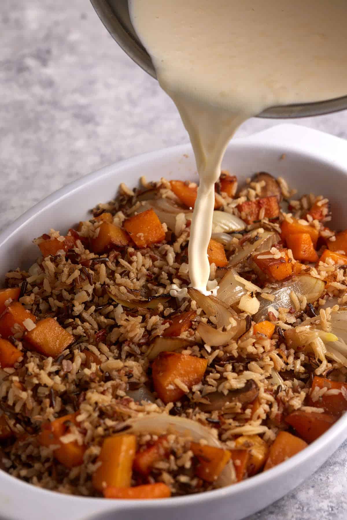 Cream being poured over a casserole.