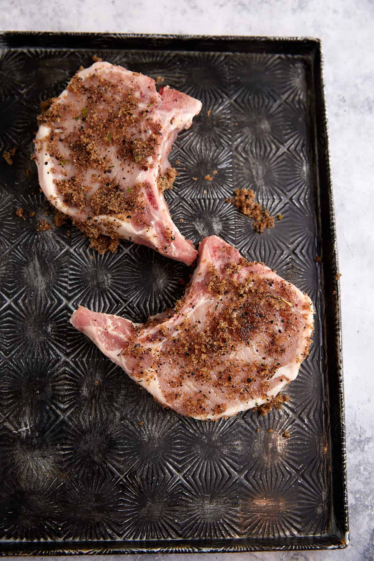 A brown sugar rub on two pork chops.
