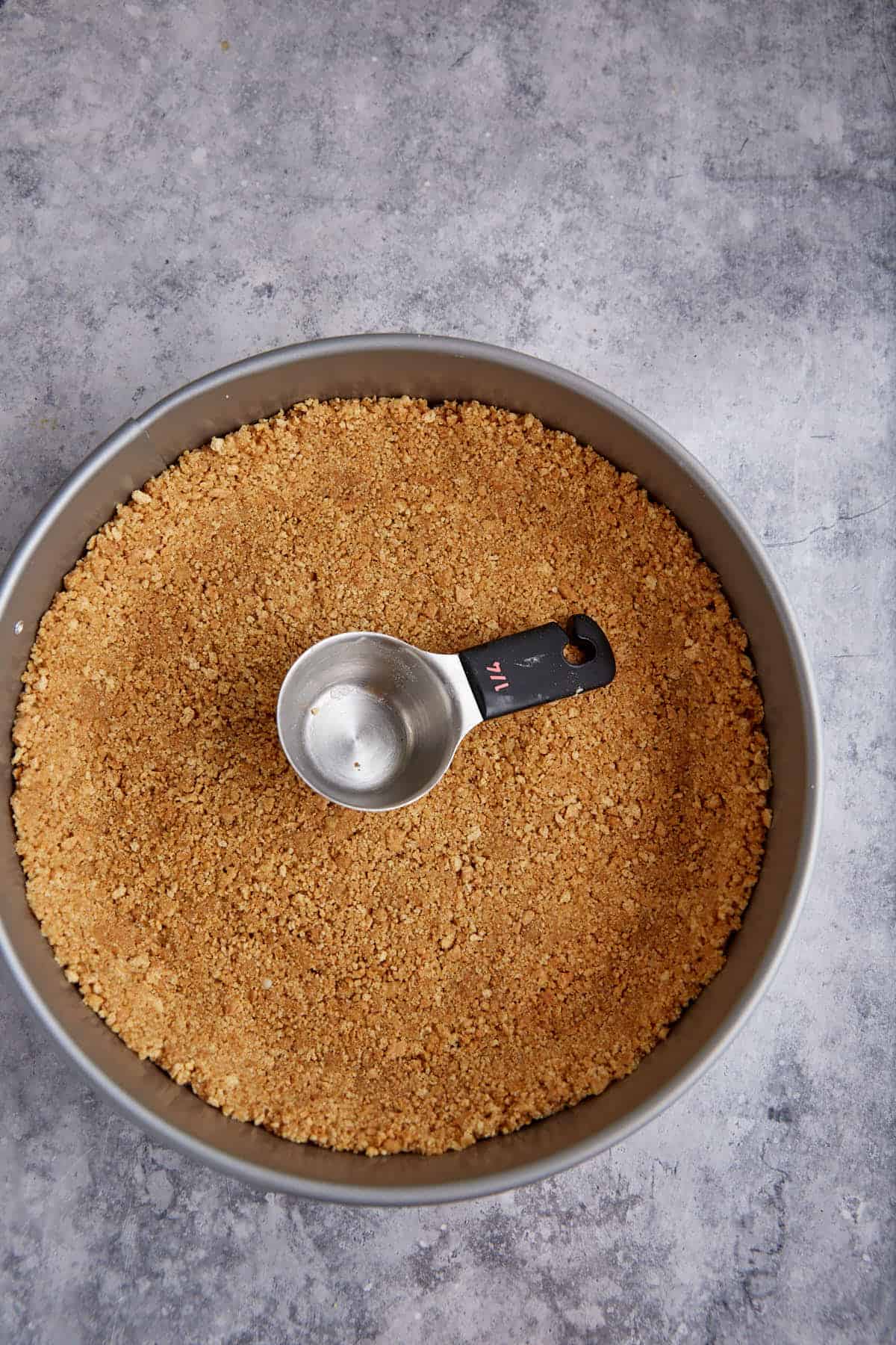 Graham cracker crust in a springform pan.