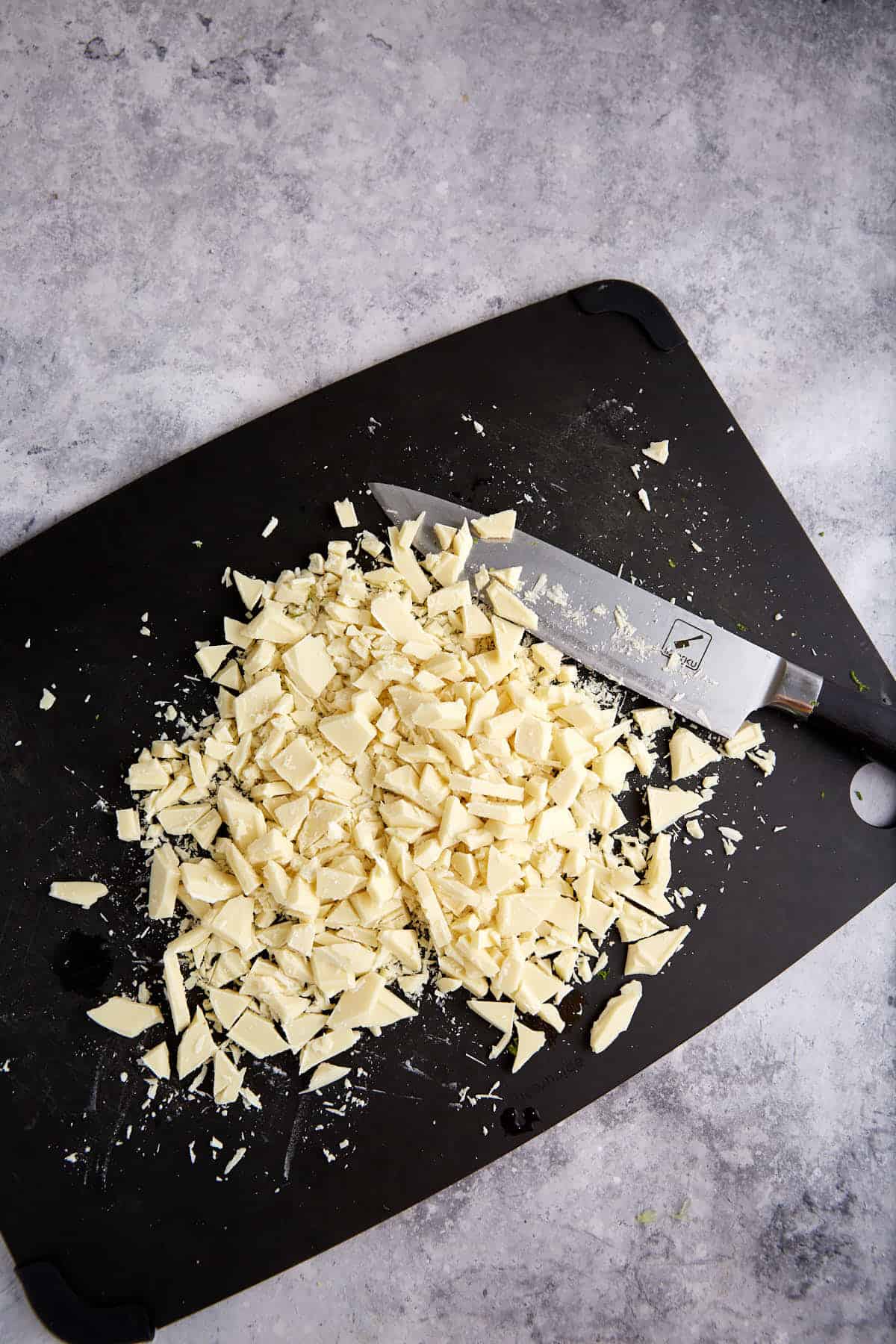 White chocolate chopped on a cutting board.