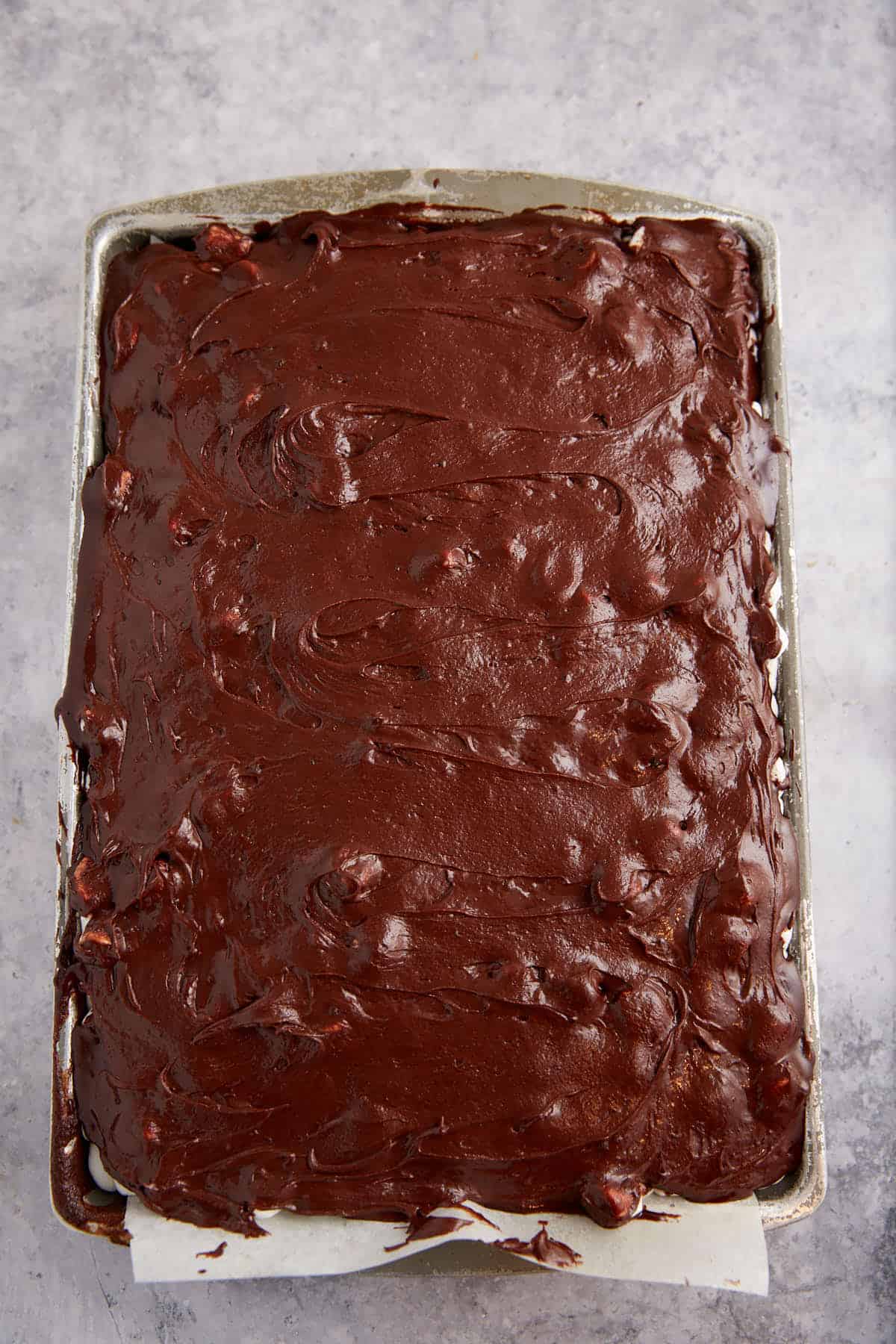 Chocolate frosting spread over the top of a cake.