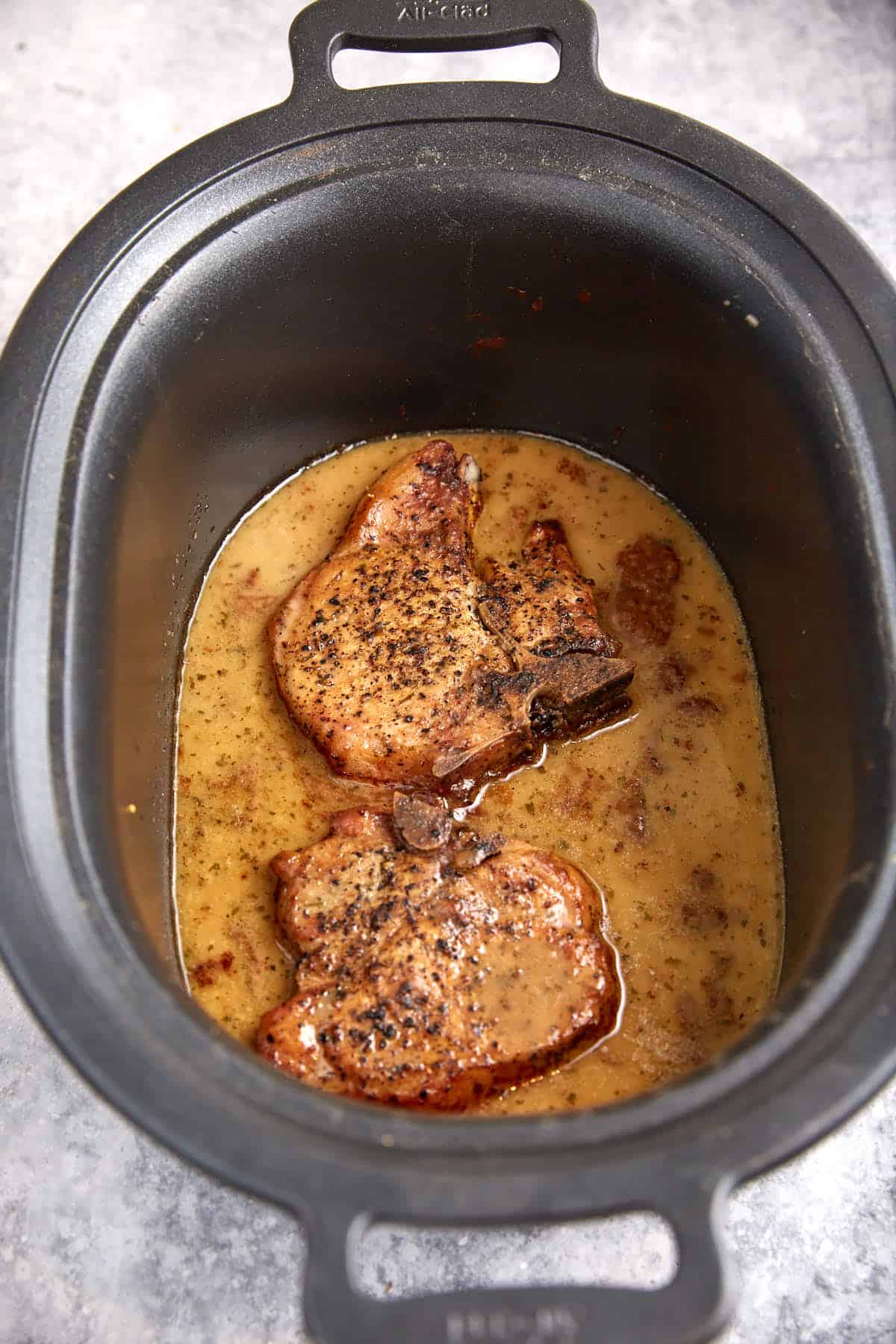 Cooked pork chops in a slow cooker.