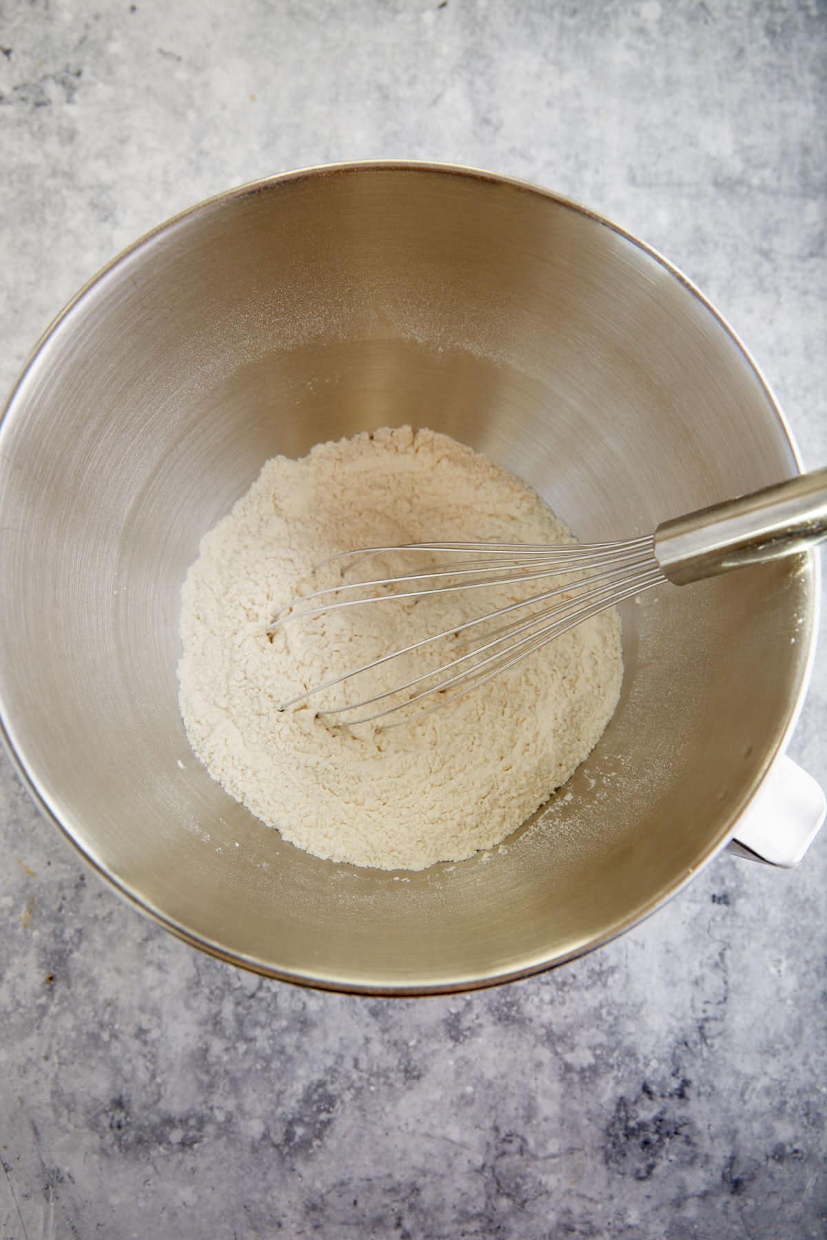 The flour mixture in a mixing bowl with a whisk.