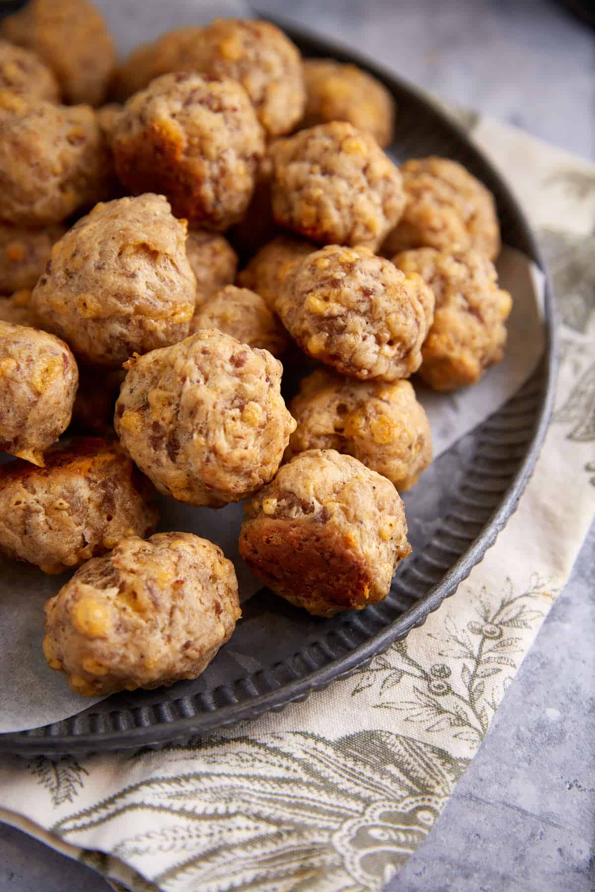 Sausage balls on a black platter.