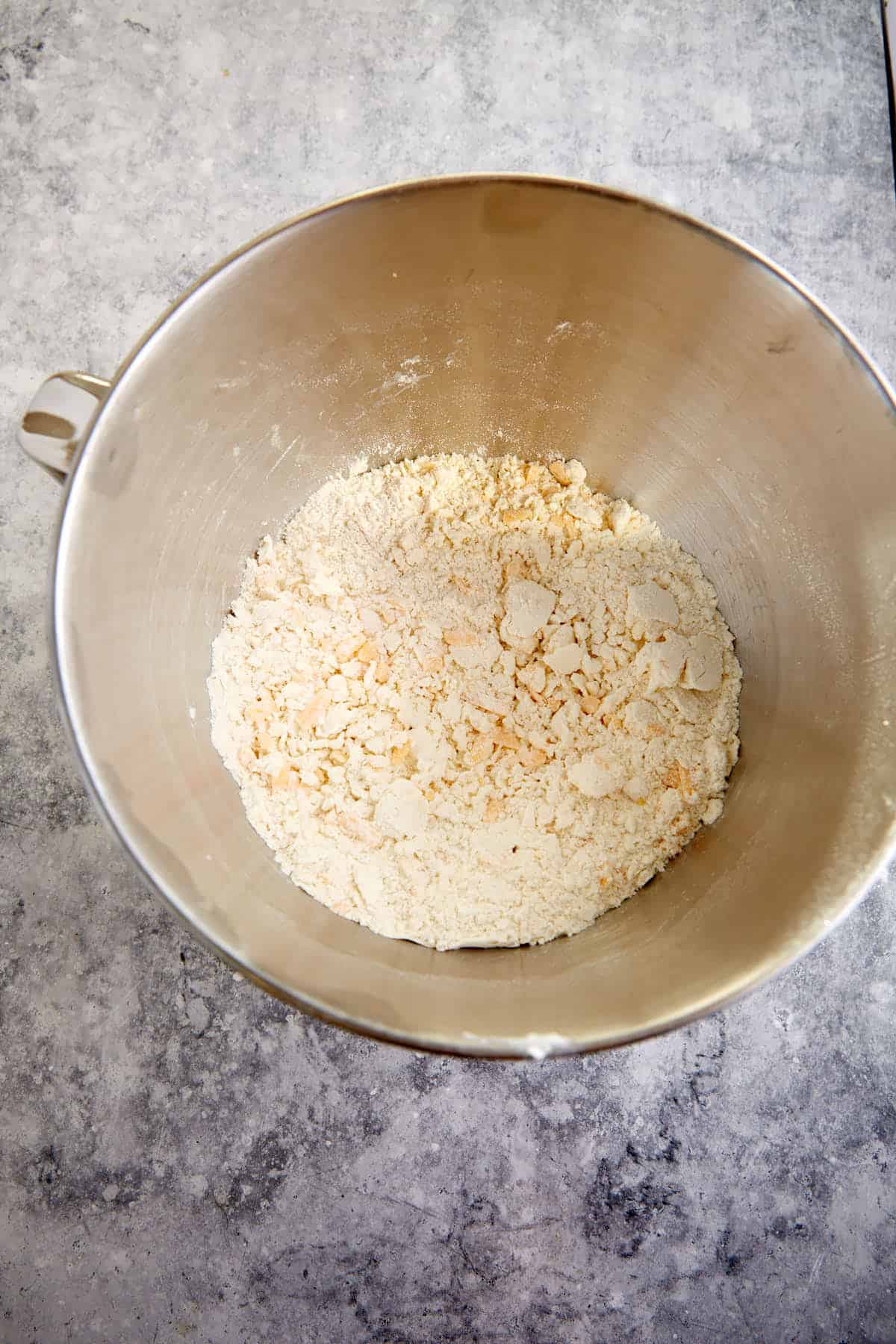 Cheese mixed with flour in a mixing bowl.