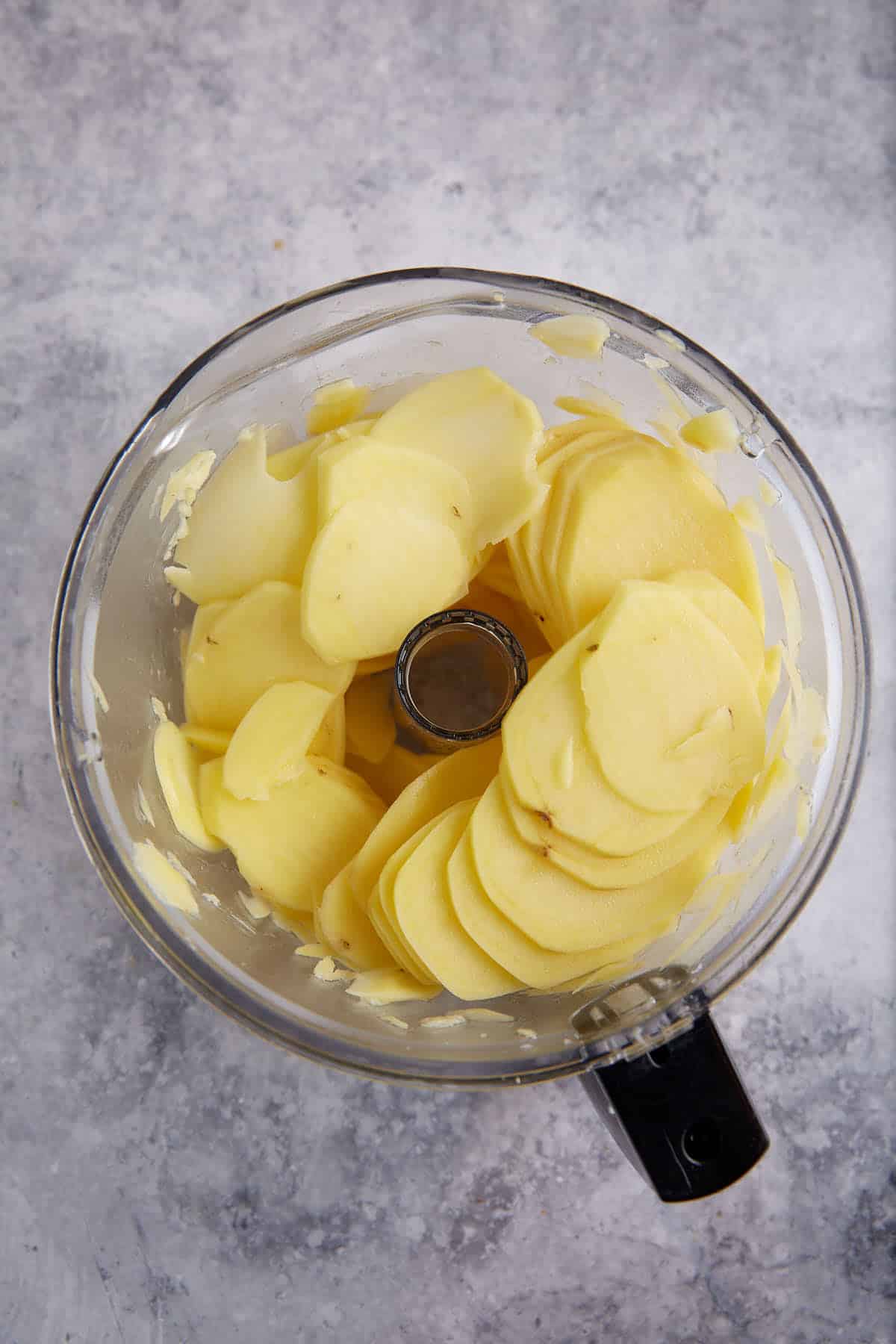 Potatoes sliced in a food processor.