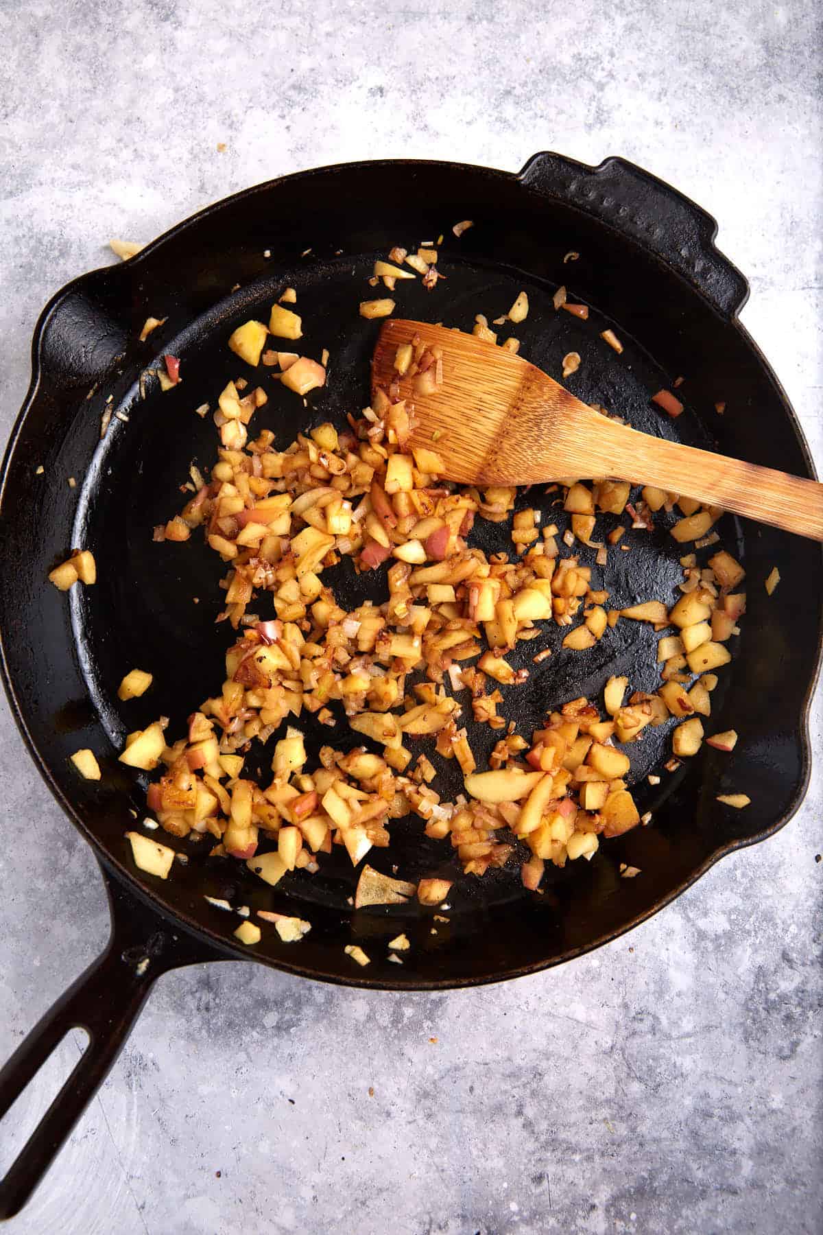 Apples and onions cooked in a skillet.