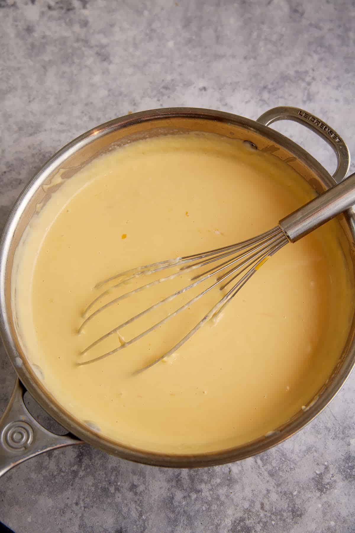 A cheese sauce in a saucepan.