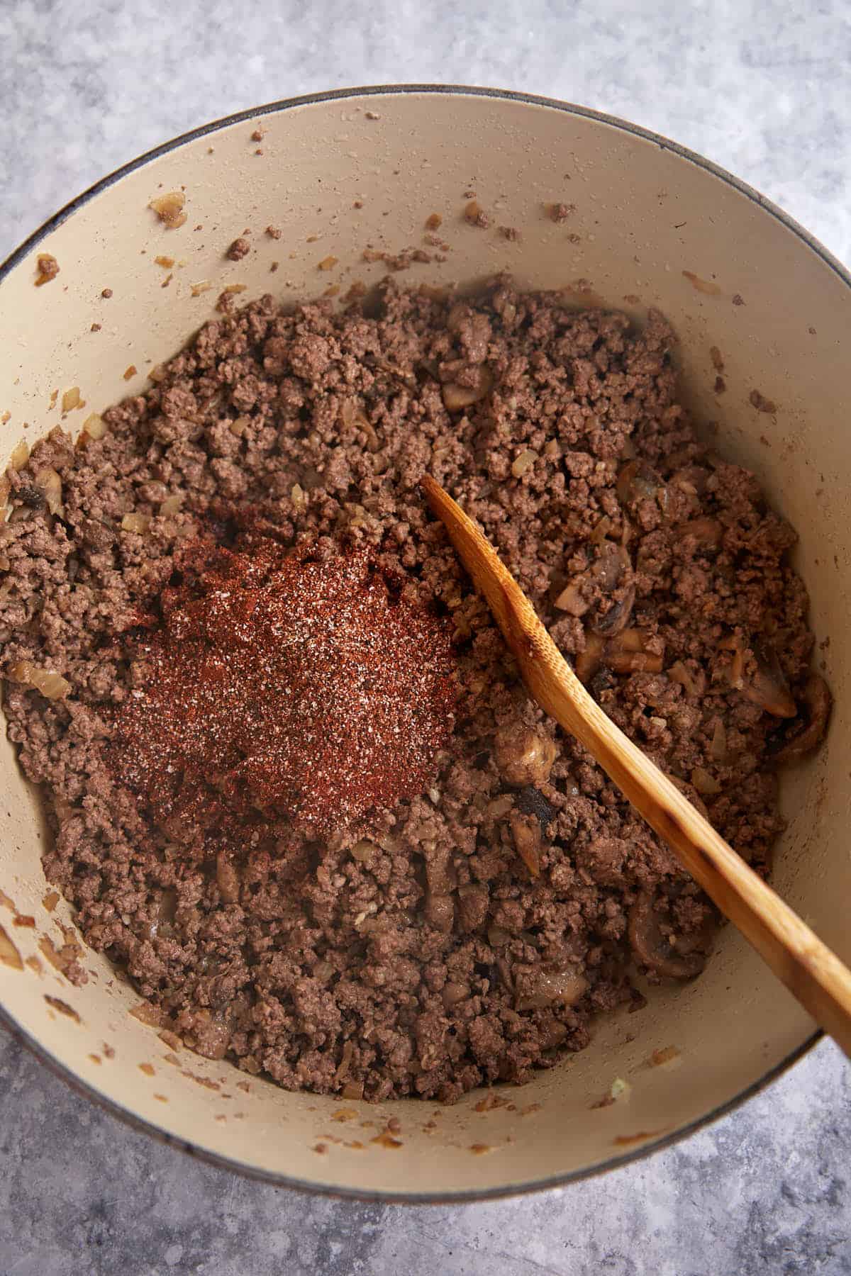 Cooked ground beef with seasonings in a pot.