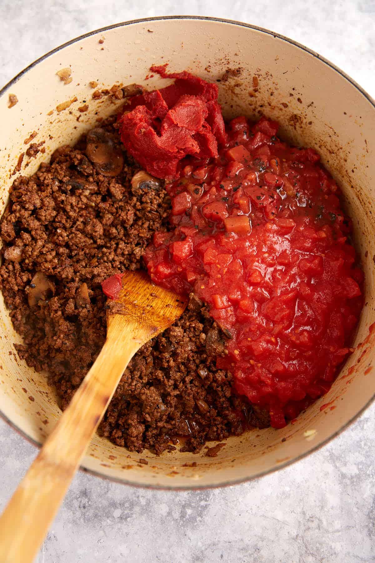 Tomatoes added to the chili in a pot.
