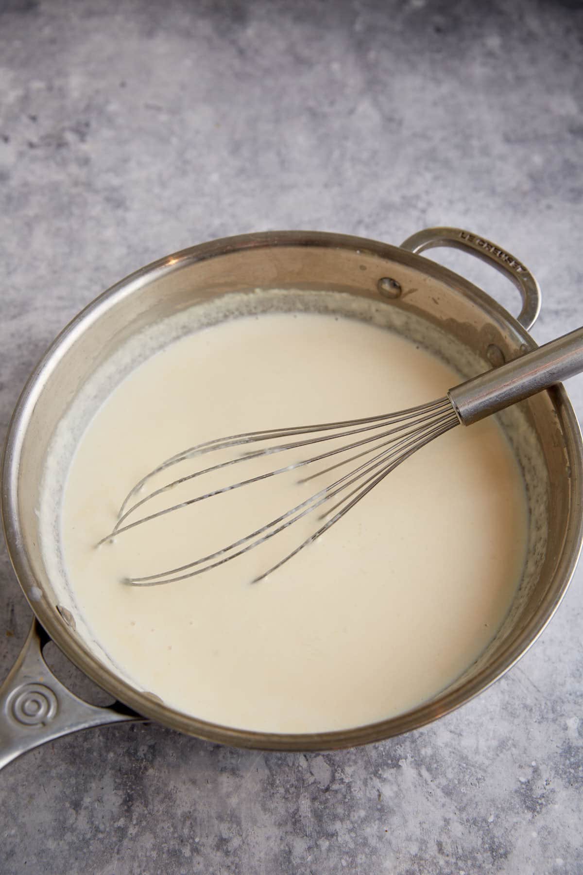 A bechemal sauce with a whisk.