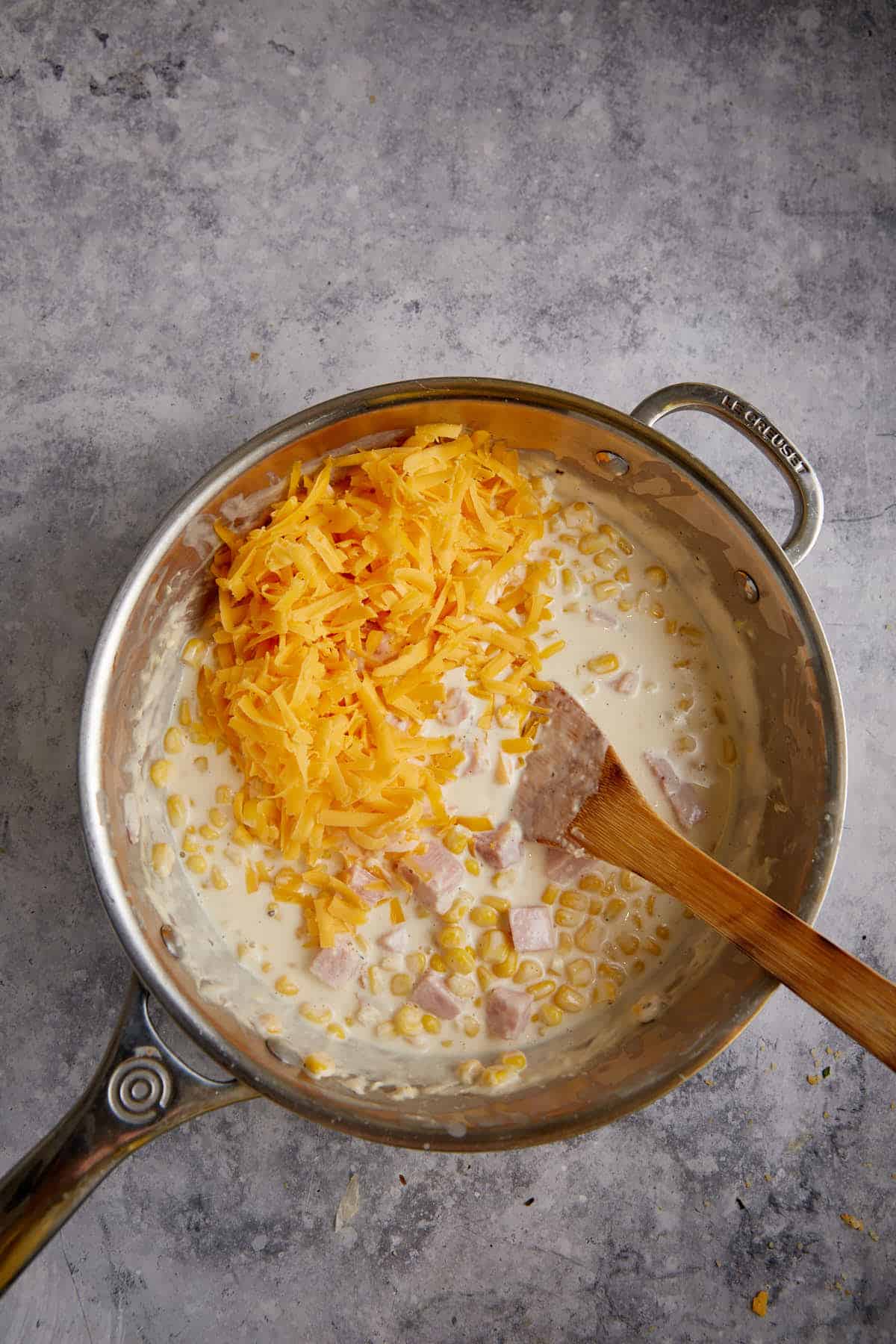 Cheese added to a saucepan.
