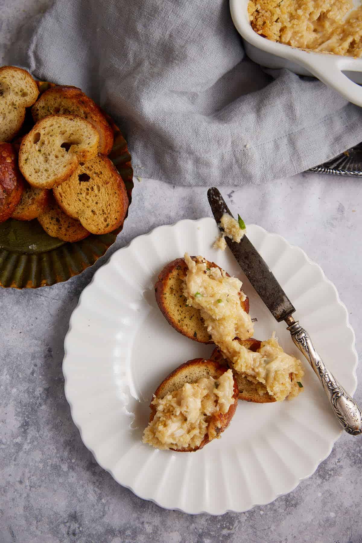 A small plate with crostini and crab dip.