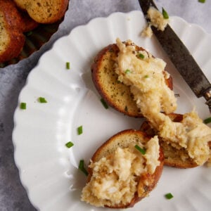 A plate of crostinis topped with crab dip.