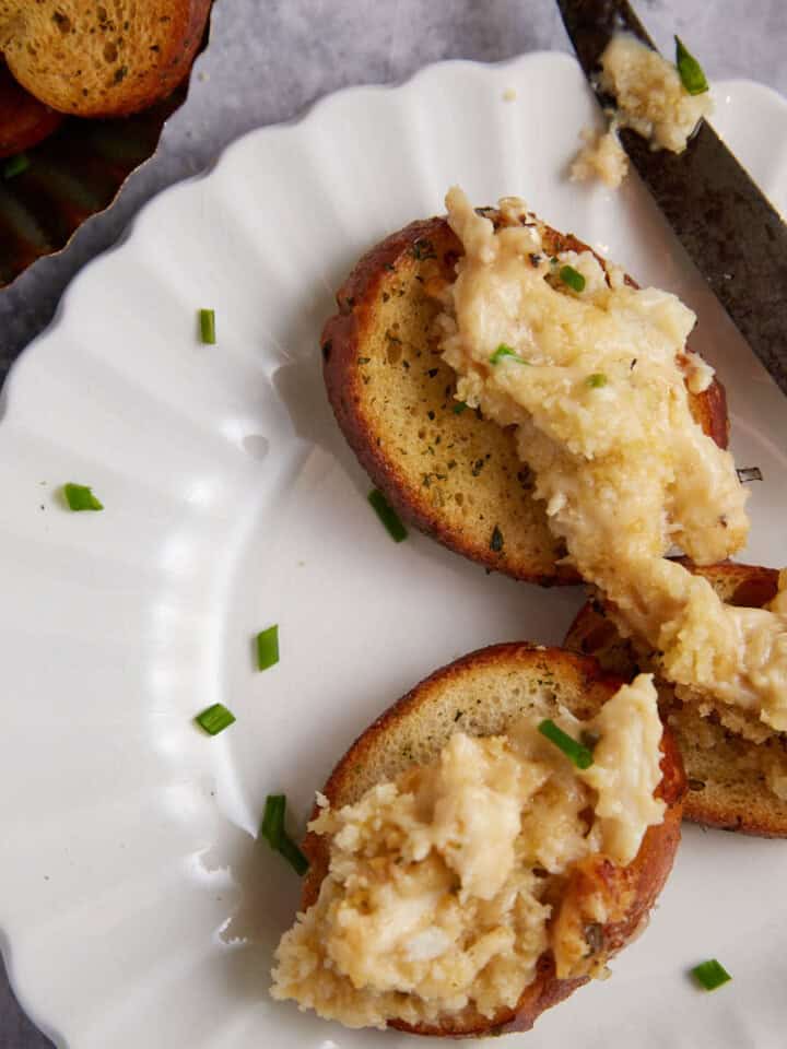 A plate of crostinis topped with crab dip.