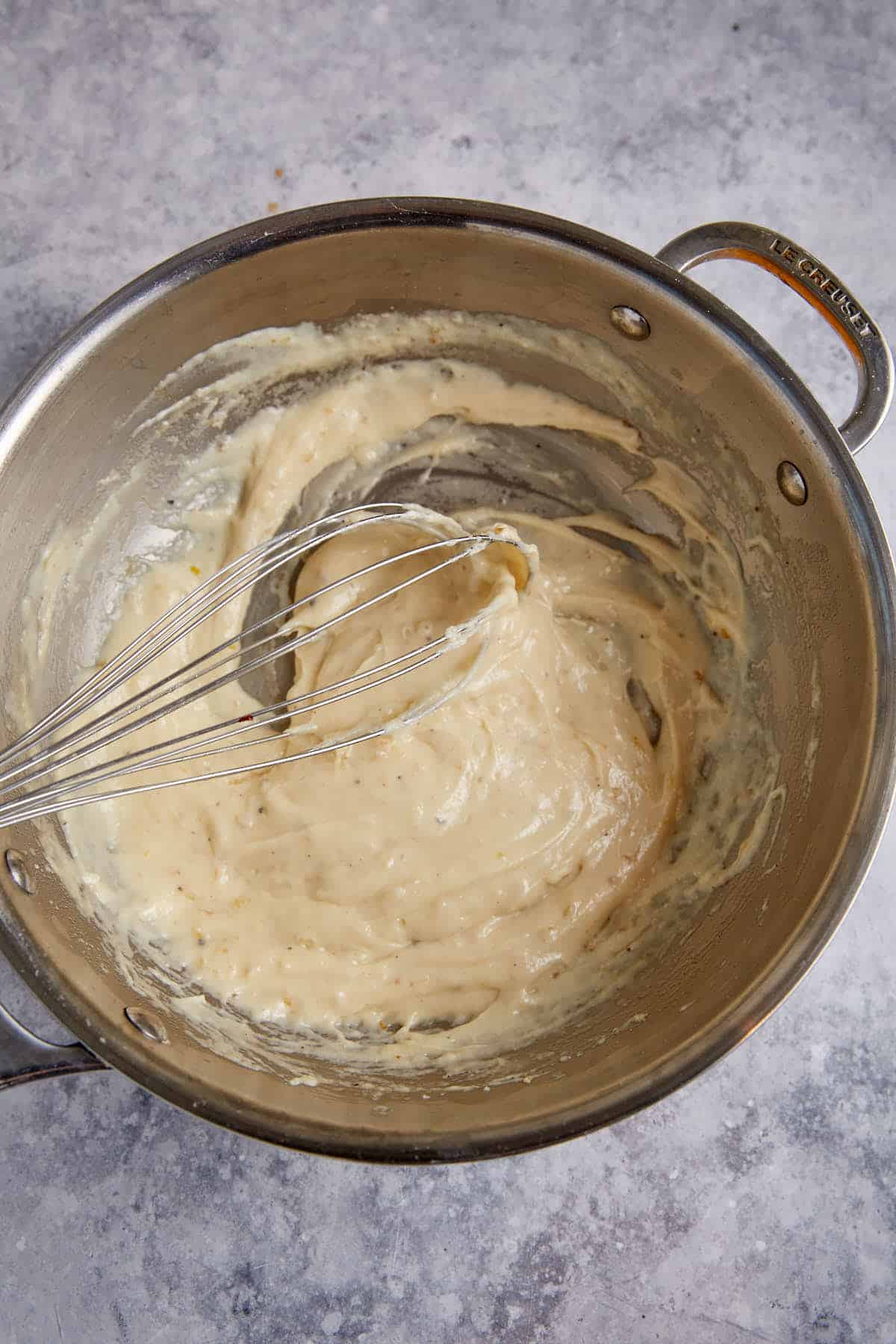 Cream added to the dip in a saucepan.
