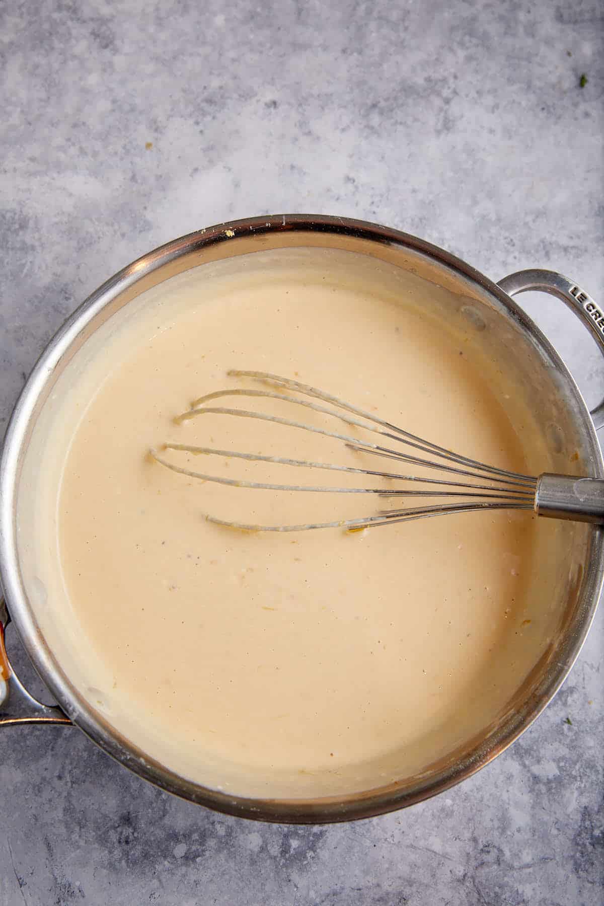 A cheese sauce in a saucepan.