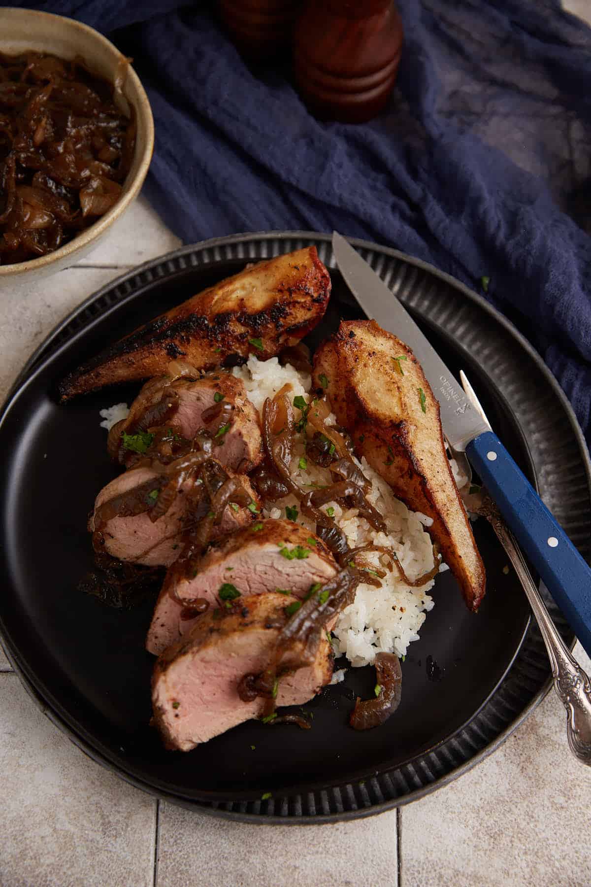 A serving of roasted pork tenderloin on a plate.