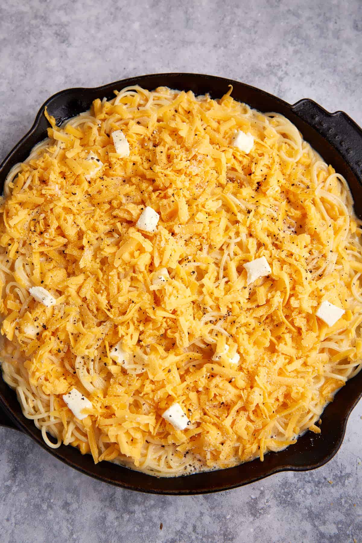 A skillet of spaghetti pie before it has baked.