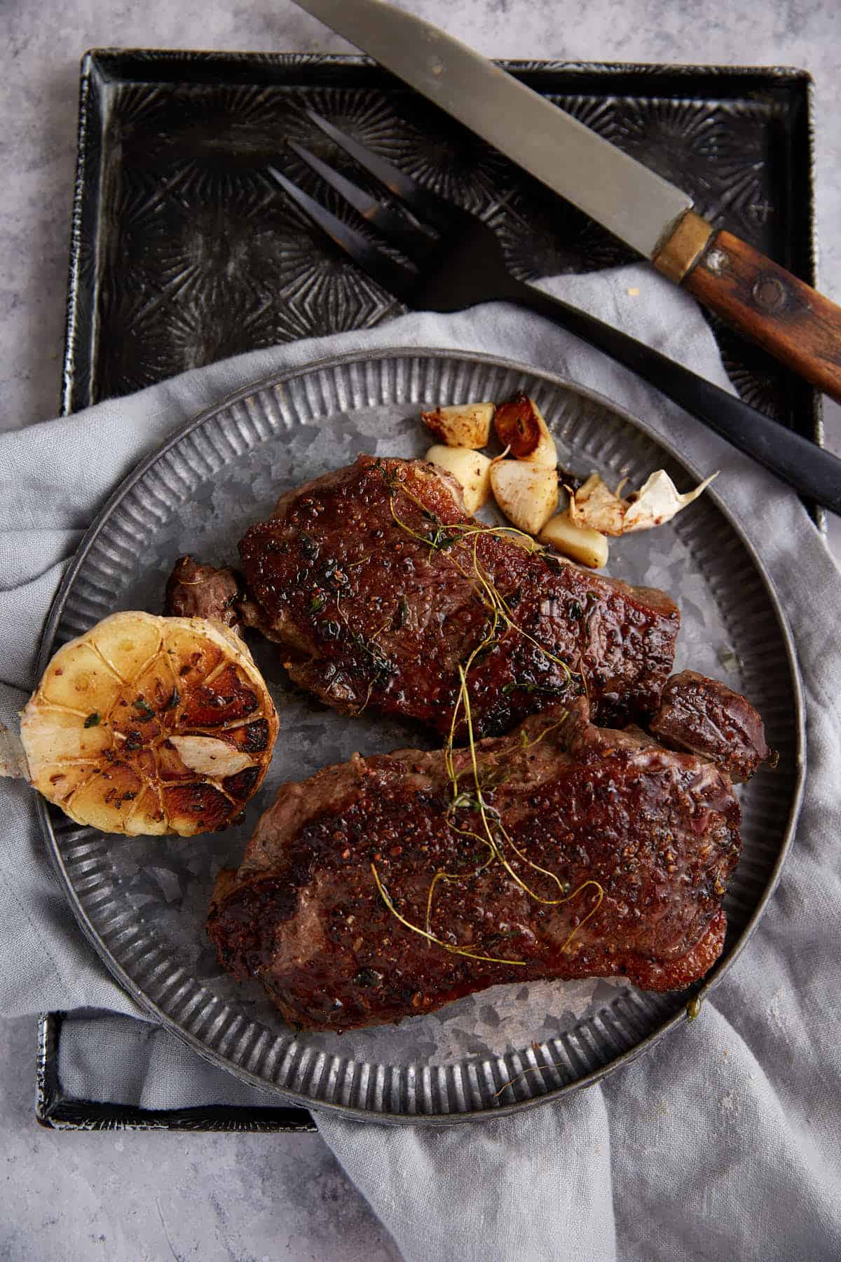Two steaks on a serving platter.