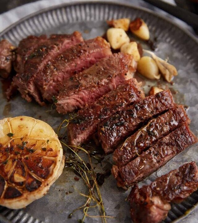 A pan seared steak sliced on a serving platter.