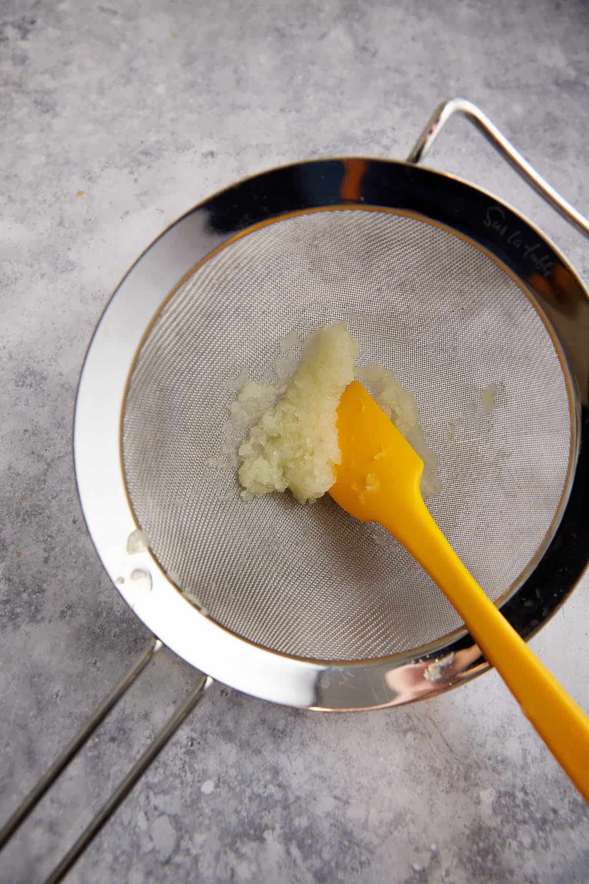 Grated onion in a sieve.