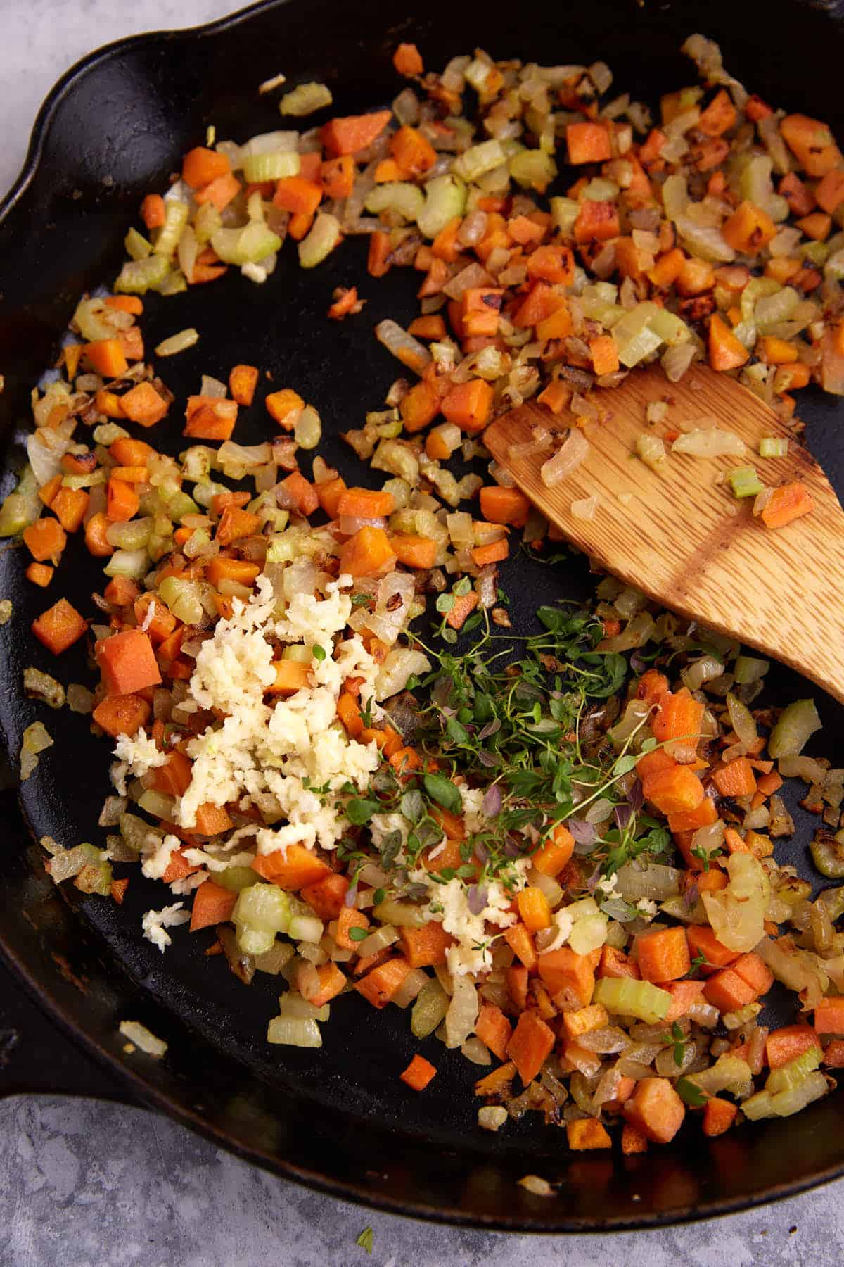 Garlic and thyme added to cooked carrots, onions and celery.