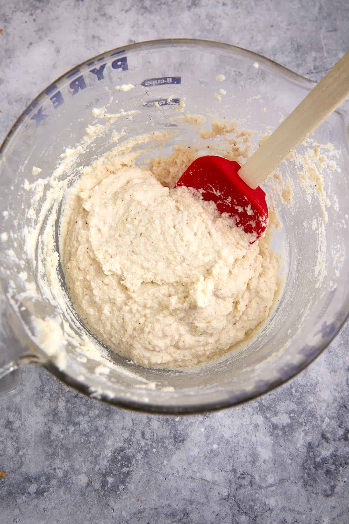 Cornbread batter in a mixing bowl with a spatula.