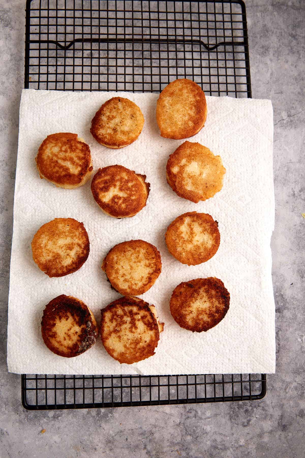 Hot water cornbread patties on a paper towel covered rack.
