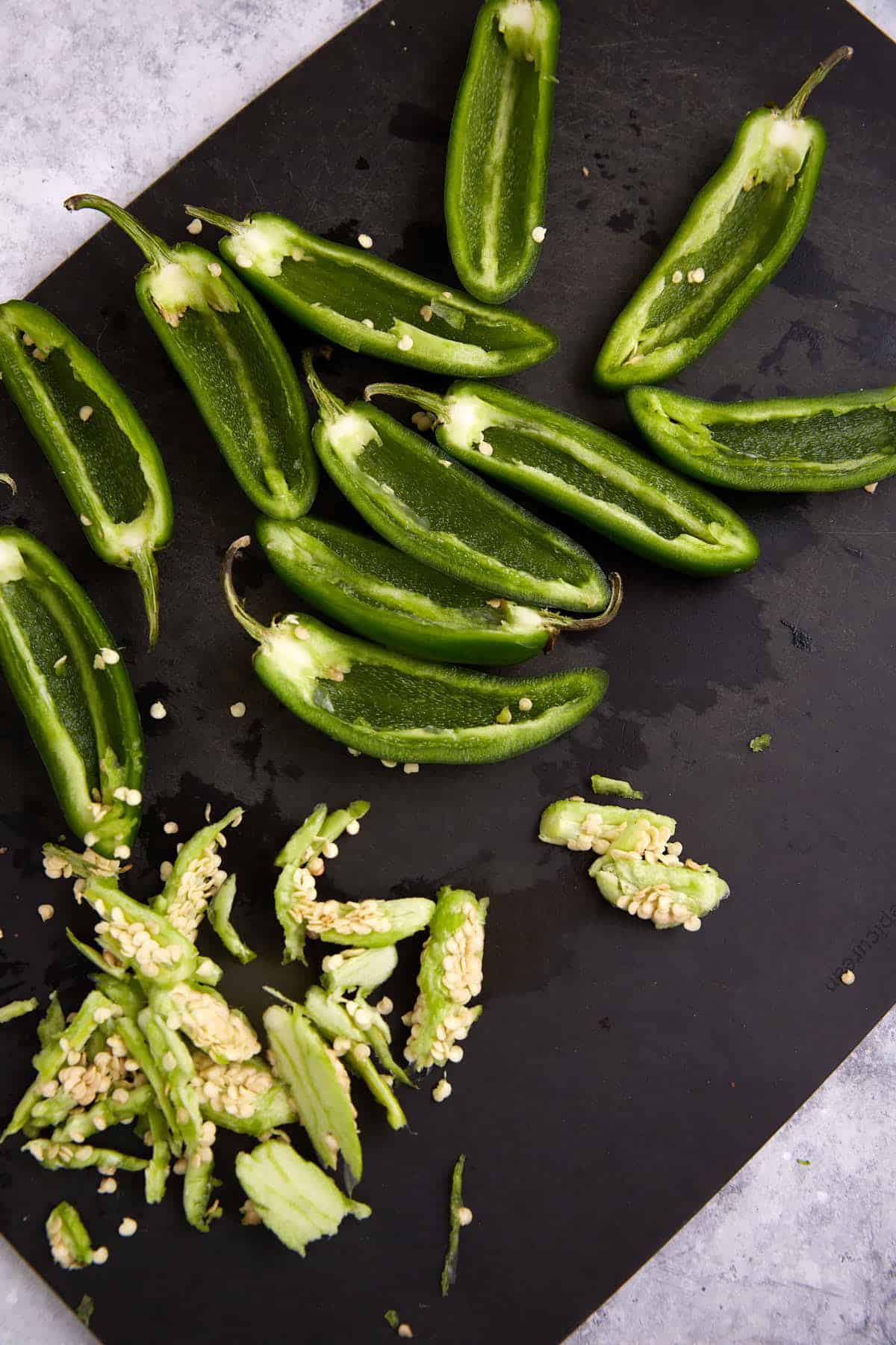 Jalapeno peppers sliced in half with seeds removed.