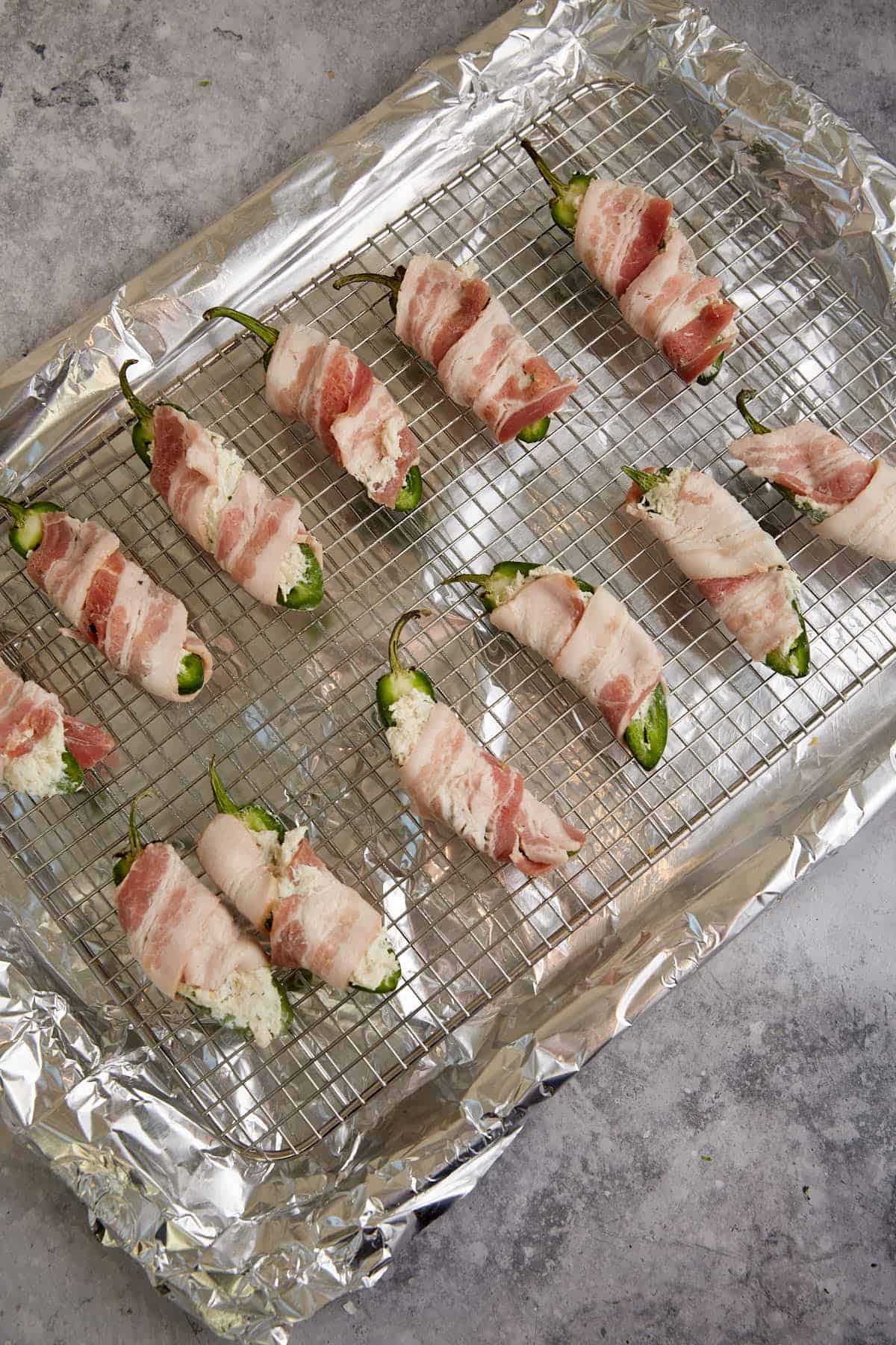 Stuffed peppers on a rack on a baking sheet.
