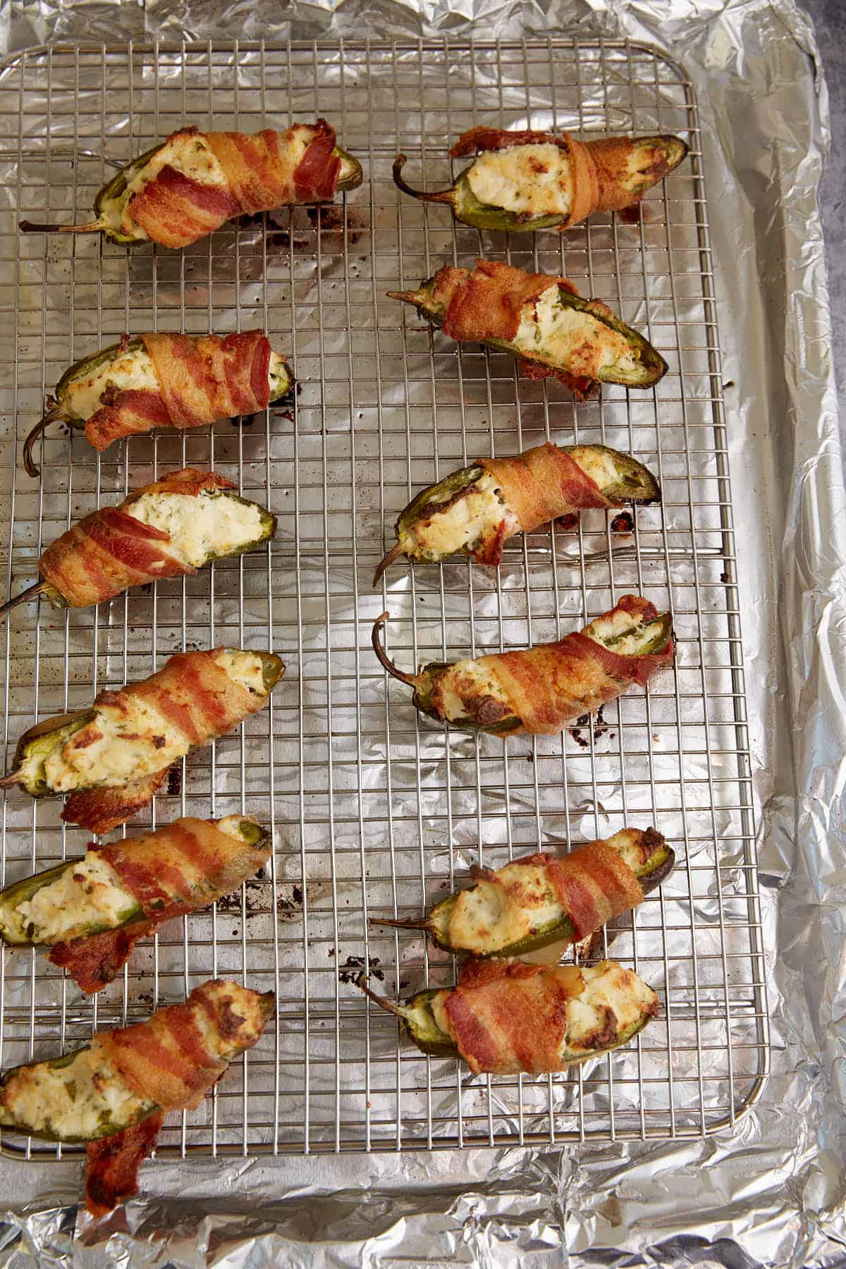 Baked jalapeno poppers on a wire rack.