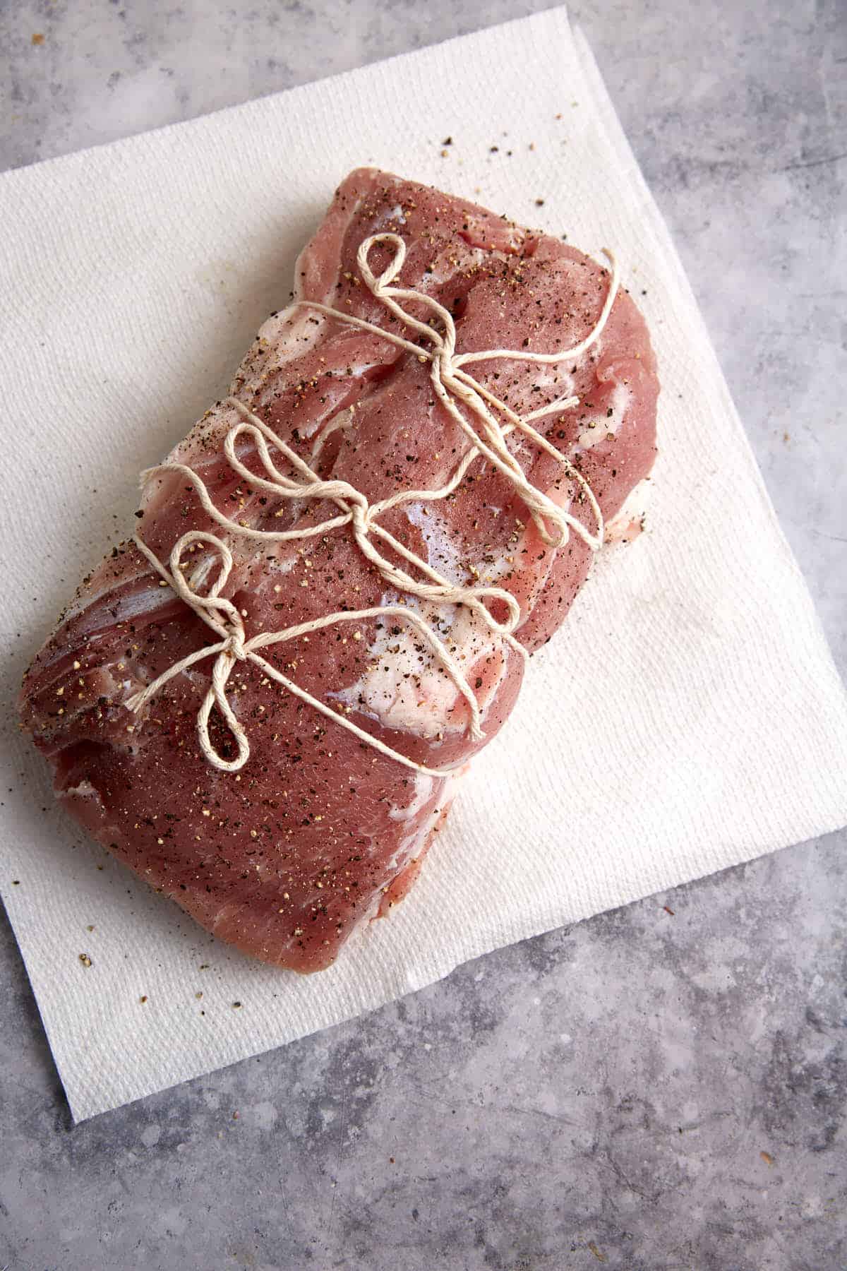 A pork loin tied up with twine.