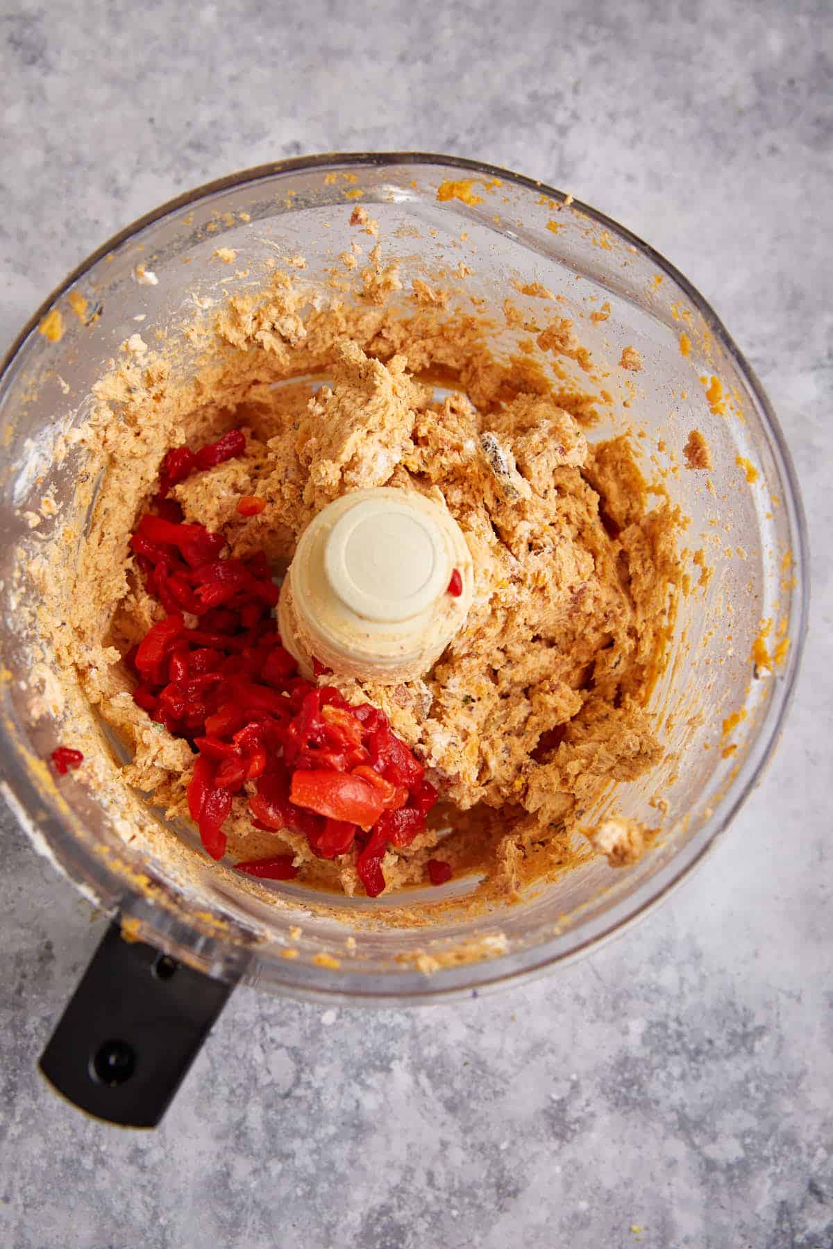 Pimentos added to a cream cheese mixture.