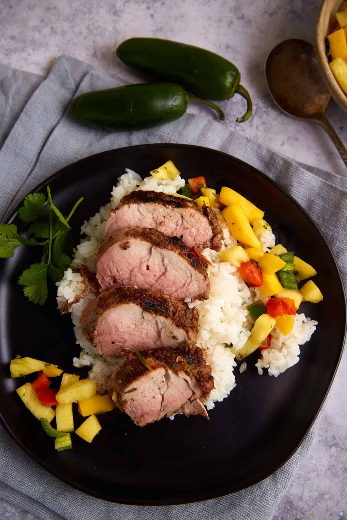 A plate of grilled pork tenderloin over rice. 