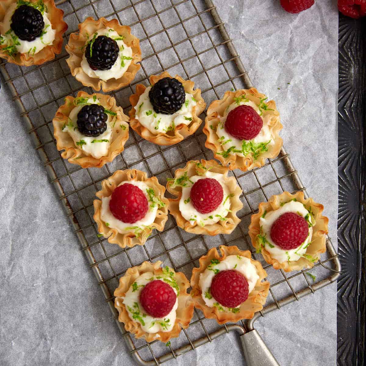 A tray of raspberry tarts in phyllo cups.